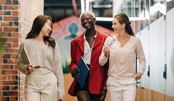 three women talking and laughing at work
